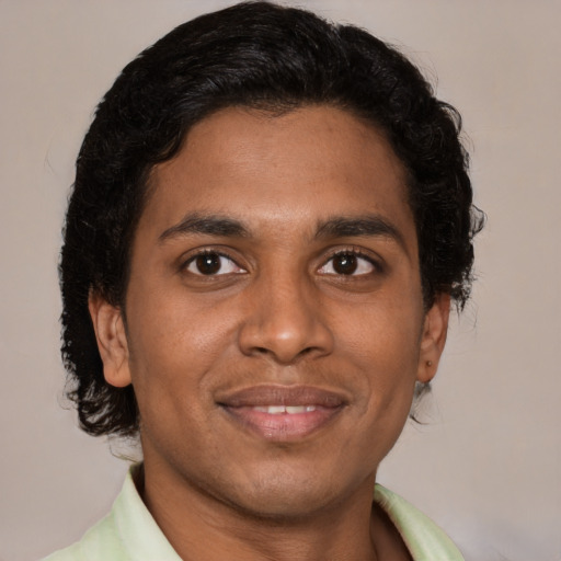 Joyful latino young-adult male with short  brown hair and brown eyes
