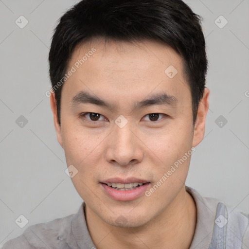 Joyful asian young-adult male with short  black hair and brown eyes