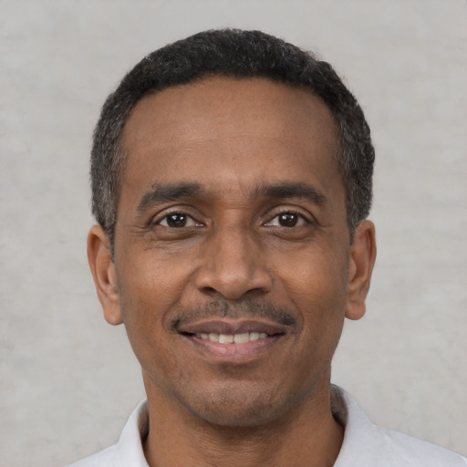 Joyful black adult male with short  black hair and brown eyes
