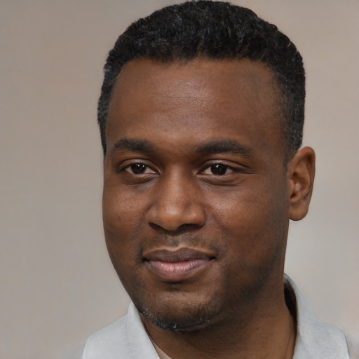 Joyful black young-adult male with short  black hair and brown eyes