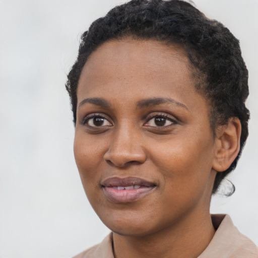 Joyful black young-adult female with short  black hair and brown eyes