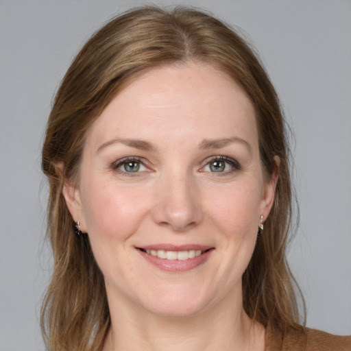 Joyful white young-adult female with medium  brown hair and grey eyes