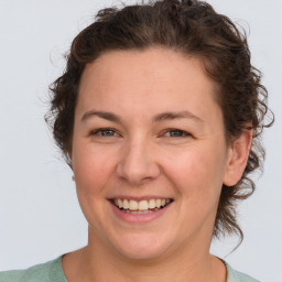 Joyful white young-adult female with medium  brown hair and green eyes