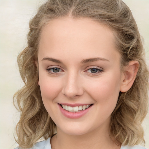 Joyful white young-adult female with long  brown hair and blue eyes