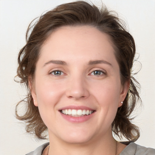 Joyful white young-adult female with medium  brown hair and blue eyes