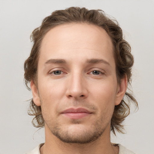 Joyful white young-adult male with medium  brown hair and grey eyes