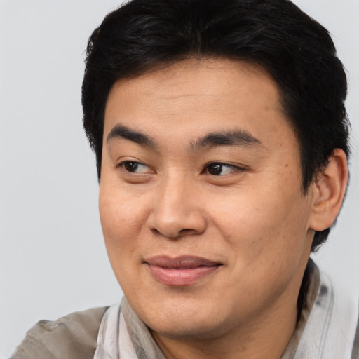 Joyful asian young-adult male with short  brown hair and brown eyes