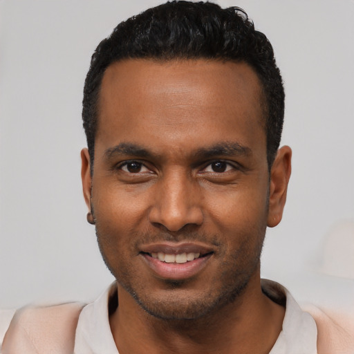 Joyful black young-adult male with short  black hair and brown eyes
