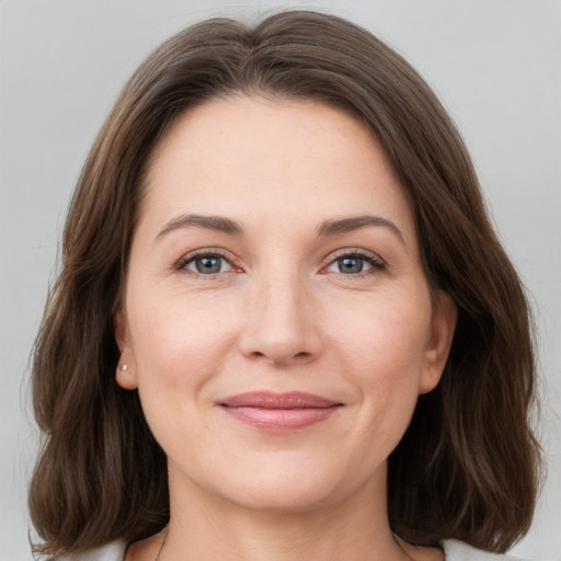 Joyful white young-adult female with medium  brown hair and grey eyes