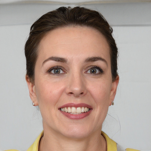 Joyful white young-adult female with short  brown hair and grey eyes