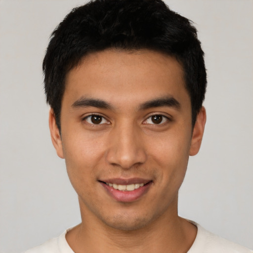 Joyful latino young-adult male with short  black hair and brown eyes