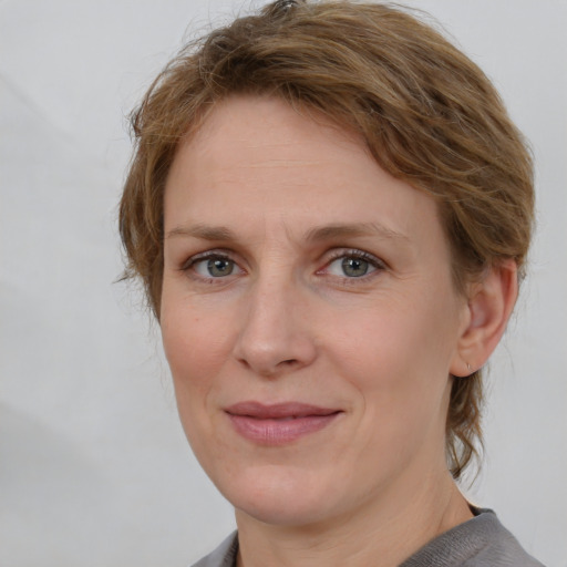 Joyful white adult female with medium  brown hair and grey eyes