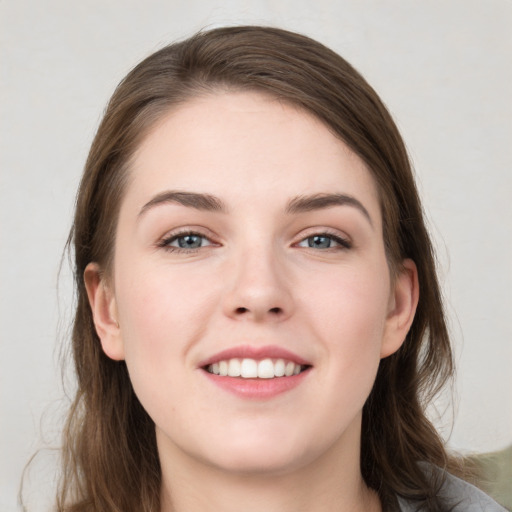 Joyful white young-adult female with long  brown hair and grey eyes