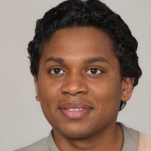 Joyful black young-adult female with short  black hair and brown eyes