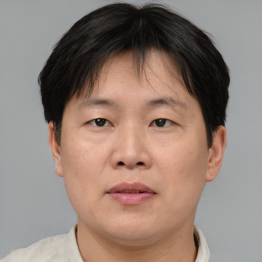 Joyful asian adult male with short  brown hair and brown eyes