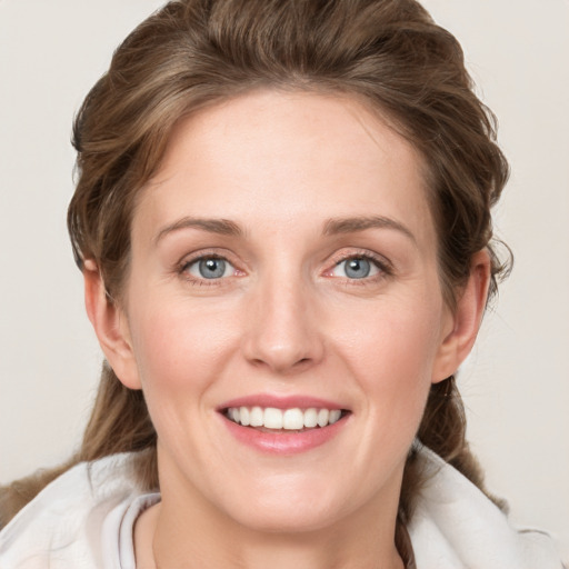 Joyful white young-adult female with medium  brown hair and blue eyes