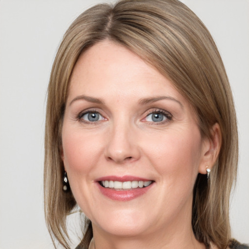 Joyful white adult female with medium  brown hair and grey eyes