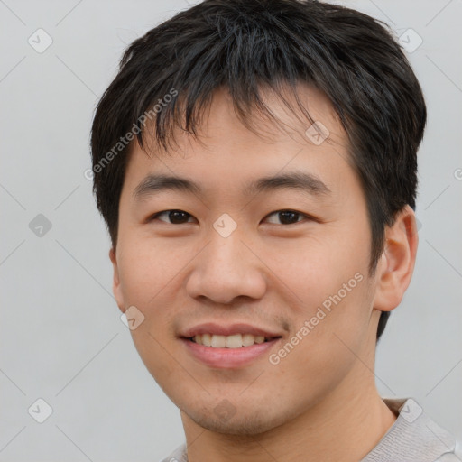 Joyful asian young-adult male with short  brown hair and brown eyes