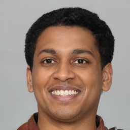 Joyful latino young-adult male with short  brown hair and brown eyes