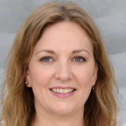 Joyful white adult female with long  brown hair and grey eyes