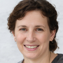 Joyful white adult female with medium  brown hair and grey eyes