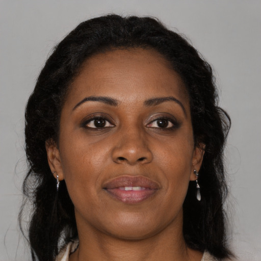 Joyful black adult female with long  brown hair and brown eyes