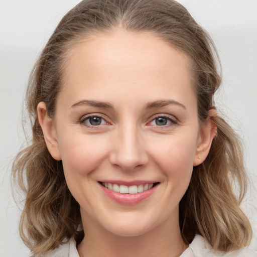 Joyful white young-adult female with medium  brown hair and grey eyes