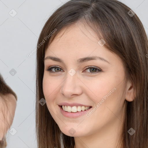 Joyful white young-adult female with long  brown hair and brown eyes