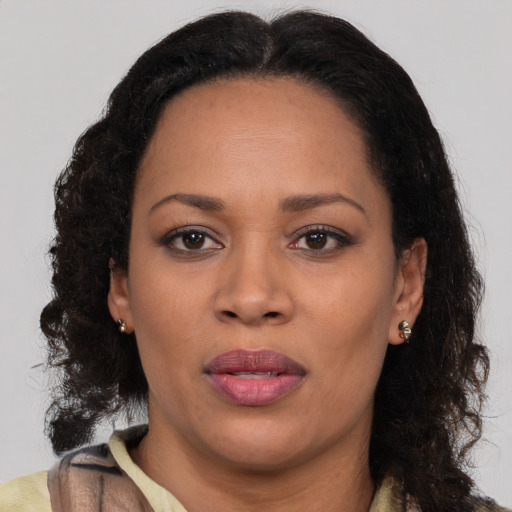 Joyful black adult female with long  brown hair and brown eyes