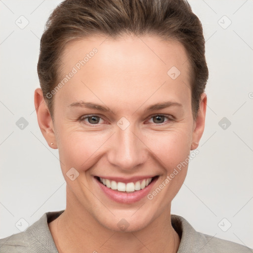 Joyful white young-adult female with short  brown hair and grey eyes