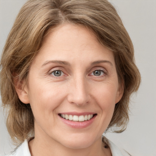 Joyful white adult female with medium  brown hair and grey eyes