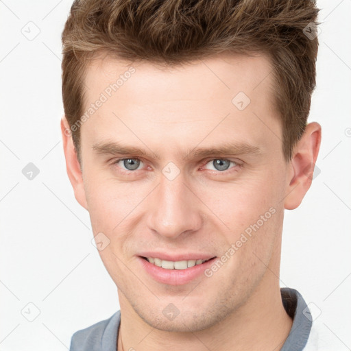 Joyful white young-adult male with short  brown hair and grey eyes