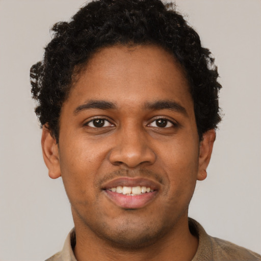 Joyful black young-adult male with short  brown hair and brown eyes