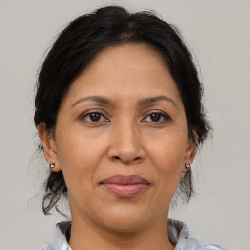 Joyful latino adult female with medium  brown hair and brown eyes