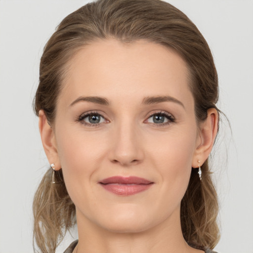 Joyful white young-adult female with medium  brown hair and grey eyes