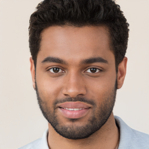 Joyful black young-adult male with short  brown hair and brown eyes