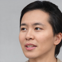 Joyful asian young-adult male with short  brown hair and brown eyes