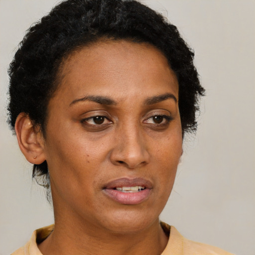 Joyful black adult female with short  brown hair and brown eyes