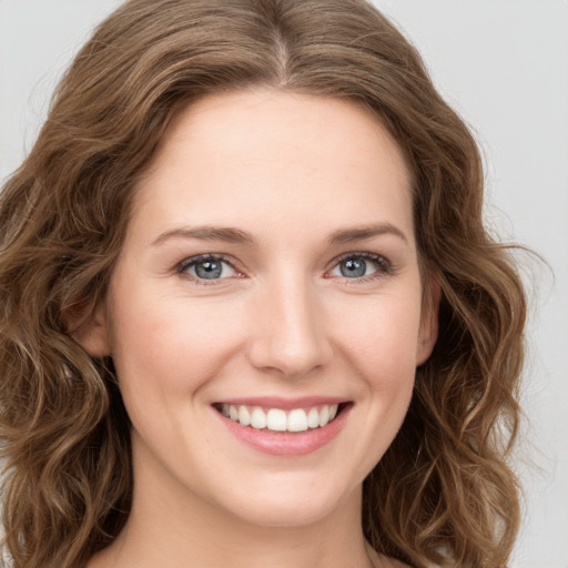 Joyful white young-adult female with long  brown hair and green eyes