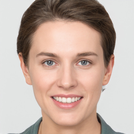 Joyful white young-adult female with short  brown hair and grey eyes