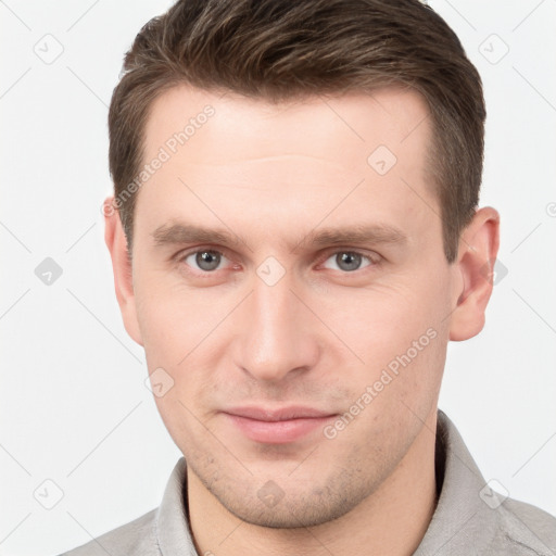 Joyful white young-adult male with short  brown hair and grey eyes