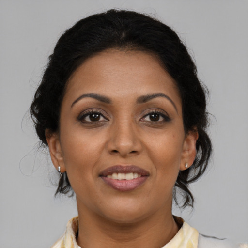 Joyful latino adult female with medium  brown hair and brown eyes