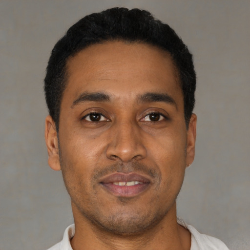 Joyful latino young-adult male with short  black hair and brown eyes