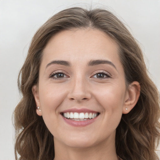 Joyful white young-adult female with long  brown hair and grey eyes