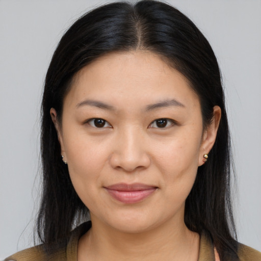 Joyful latino young-adult female with long  brown hair and brown eyes