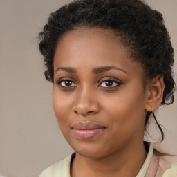 Joyful black young-adult female with long  brown hair and brown eyes