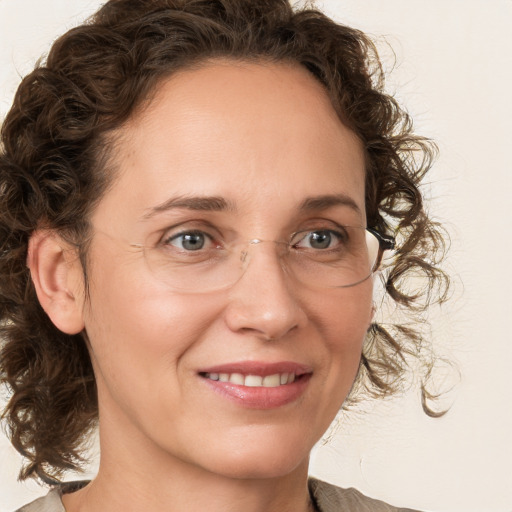 Joyful white adult female with medium  brown hair and green eyes