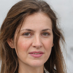 Joyful white adult female with long  brown hair and grey eyes