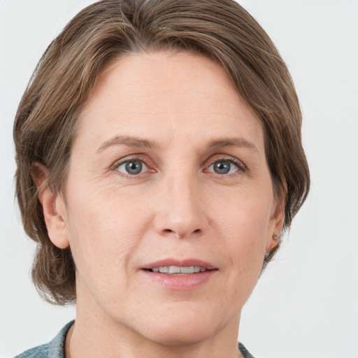 Joyful white adult female with medium  brown hair and grey eyes