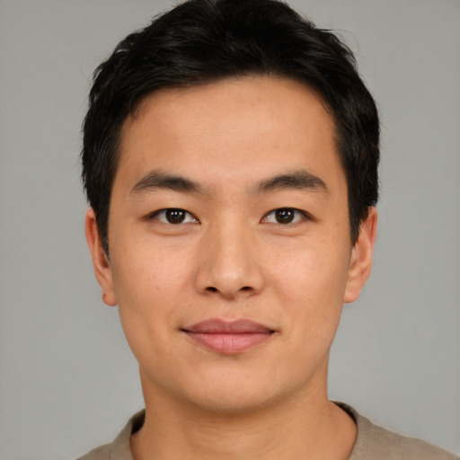 Joyful asian young-adult male with short  brown hair and brown eyes